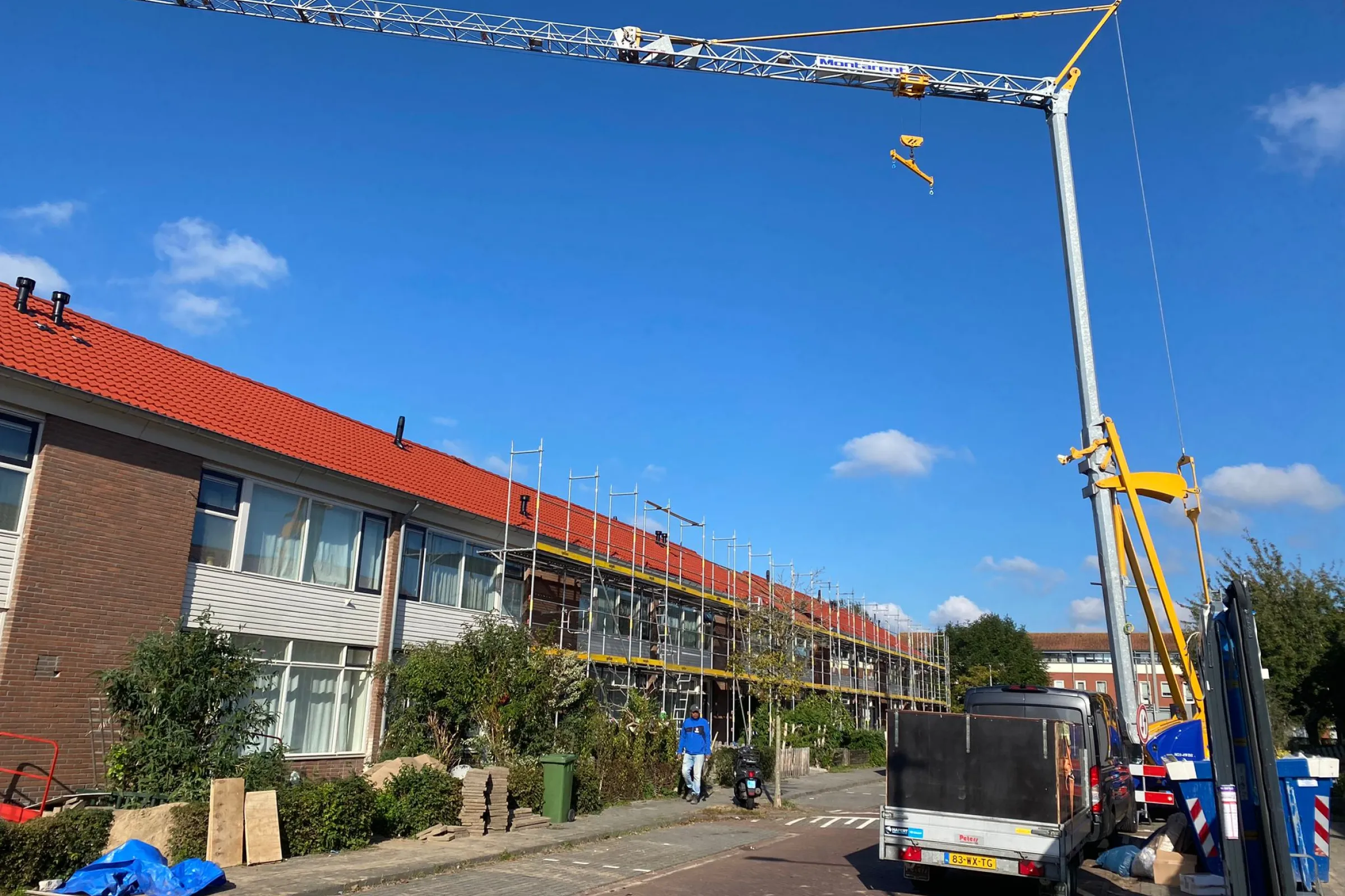 Hijskraan staat voor rij woningen